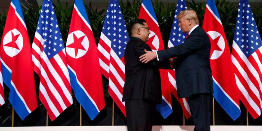 Nordkoreas Machthaber Kim Jong Un (l.) und der US-amerikanische Präsident Donald Trump geben sich nach ihrem ersten Treffen in Singapur im Juni 2018 die Hand.