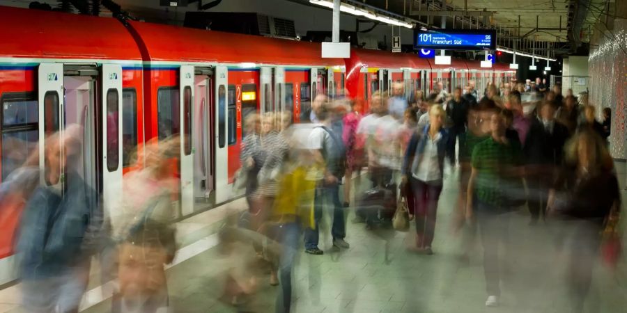 Viele Menschen verlassen eine gerade eingefahrene S-Bahn im unteren Teil des Hauptbahnhofs in Frankfurt am Main (D).