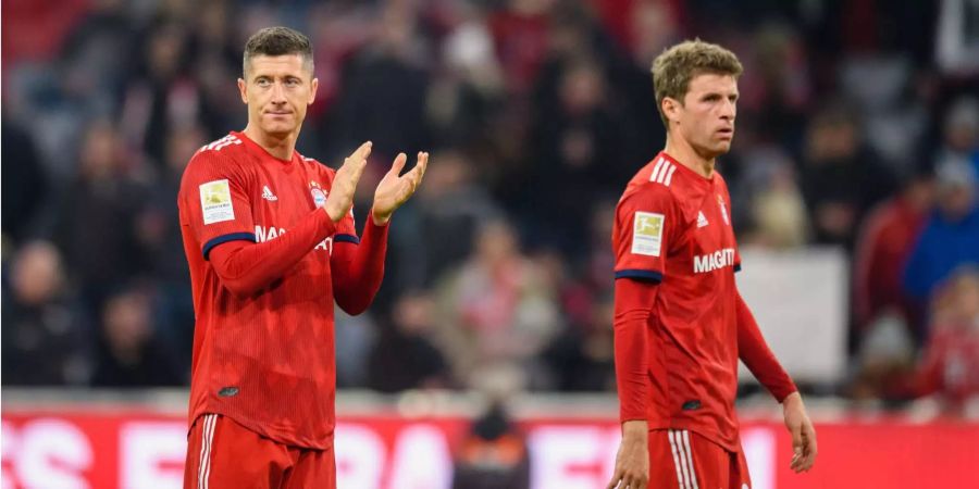 Robert Lewandowski (l) und Thomas Müller vom FC Bayern München bedanken sich nach Spielende mit verhalten zufriedenem Gesichtsausdruck bei den Fans.