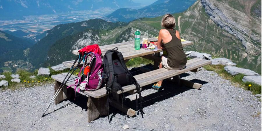 Eine Frau geniesst die Aussicht bei der Caband de Plan Neve mit Blick auf den Genfersee.