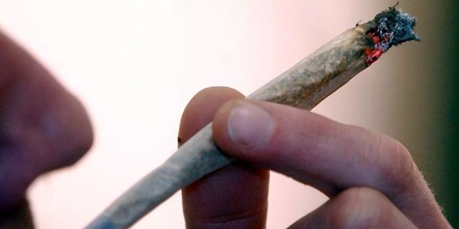 Mann mit Joint in der Hand