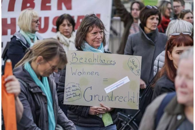 Eine Frau demonstriert im Stadtteil Nordend in Frankfürt am Main für bezahlbaren Wohnraum mit einem Plakat. Eine Frau demonstriert im Stadtteil Nordend in Frankfürt am Main für bezahlbaren Wohnraum mit einem Plakat.