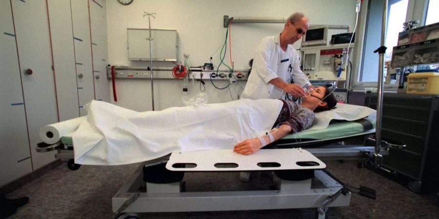 Ein Pfleger betreut eine Patientin, gestellte Aufnahme vom 6. Dezember 2001, im Spital Uznach.