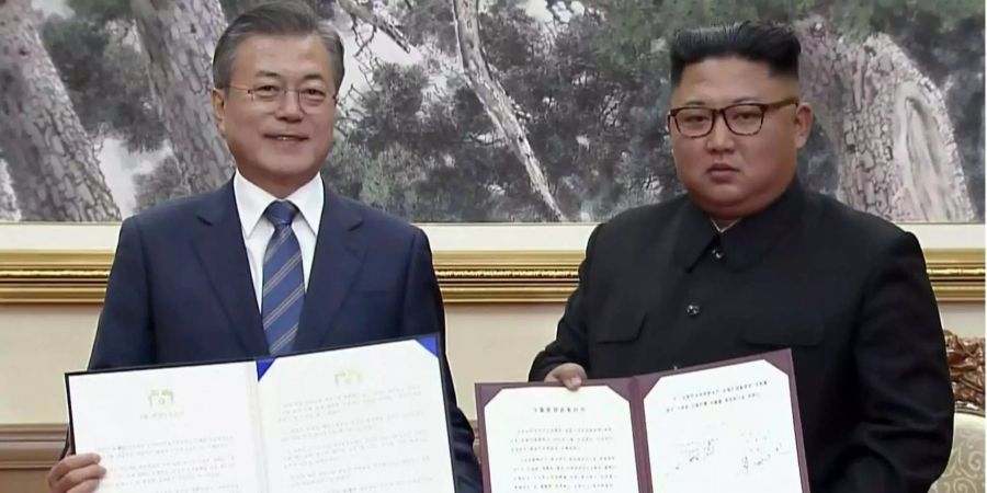 In diesem Bild aus einem Video von Korea Broadcasting System (KBS), zeigen Moon Jae In (l.), Präsident von Südkorea, und Kim Jong Un (r.), Nordkoreas Machthaber, die beim Korea-Gipfel der beiden Nachbarländer in Pjöngjang unterzeichneten Dokumente.