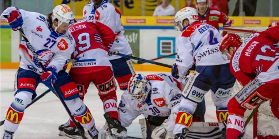 ZSC Lions Torhüter Lukas Flüeler (Mitte) versucht den Puck zu blockieren.