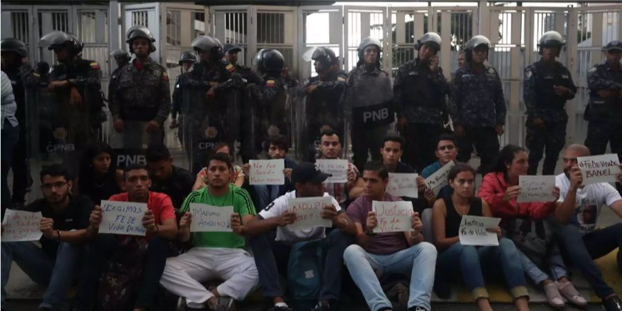 Unterstützer des inhaftierten, venezolanischen Oppositionspolitiker Fernando Albán demonstrieren sitzend vor einem Gebäude des Geheimdienstes Sebin am Venezuela-Platz in Caracas, von dessen zweiten Stock aus sich Albán in den Tod gestürzt haben soll.