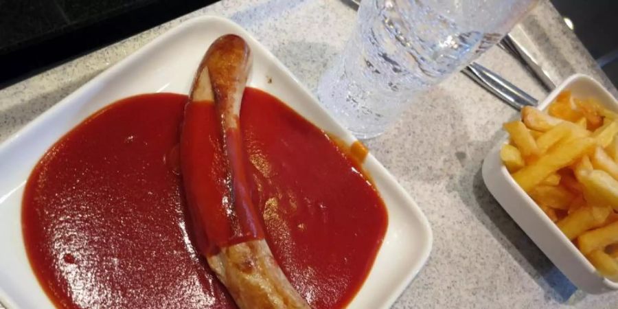 Die Currywurst hat in der Corona-Krise ihre Spitzenposition als beliebtstes Essen in den deutschen Betriebskantinen verloren. Foto: picture alliance / Martin Gerten/dpa