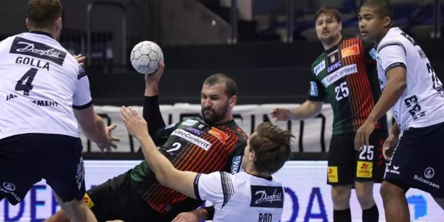 Die SG Flensburg-Handewitt (weisse Trikots) verteidigte in Magdeburg die Tabellenführung in der Handball-Bundesliga. Foto: Ronny Hartmann/dpa