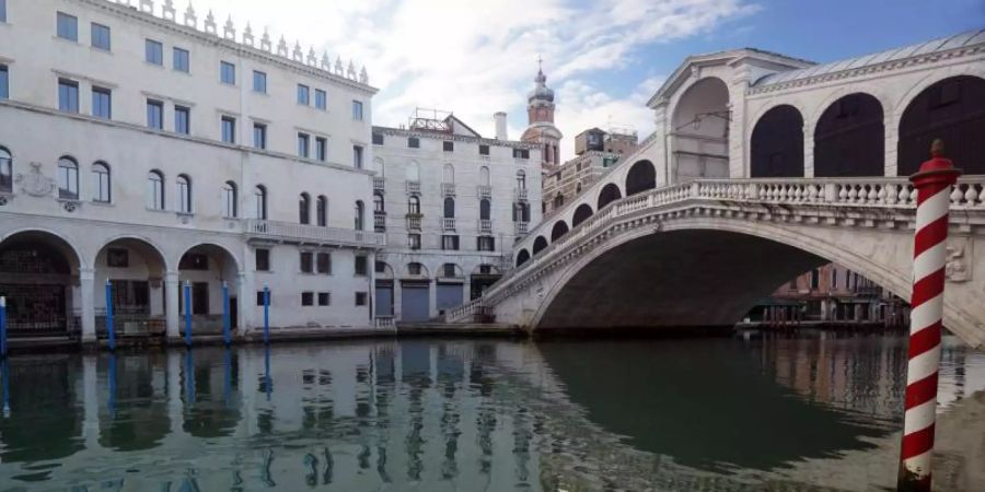 Die menschenleere Rialtobrücke spiegelt sich im Canal Grande. Foto: Anteo Marinoni/LaPresse/AP/dpa