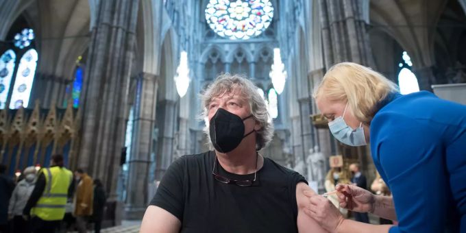 Stephen Fry, Schauspieler und Schriftsteller aus Grossbritannien, wird in der Poets' Corner, einem Teil des Querschiffs der zu einer Impfstelle umfunktionierten Kirche Westminster Abbey, gegen Corona geimpft. Coronavirus - Grossbritannien