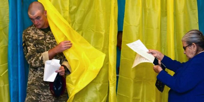 Ein ukrainischer Soldat kommt aus einer Wahlkabine Foto: Zoya Shu/AP Ein ukrainischer Soldat kommt aus einer Wahlkabine Foto: Zoya Shu/AP