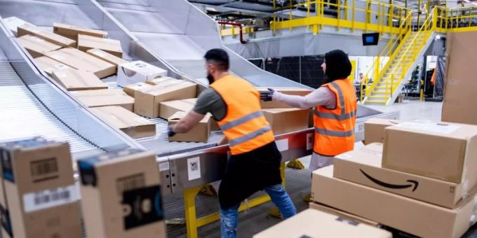 Mitarbeiter des Paketversenders Amazon sortieren Pakete. Cyber Monday