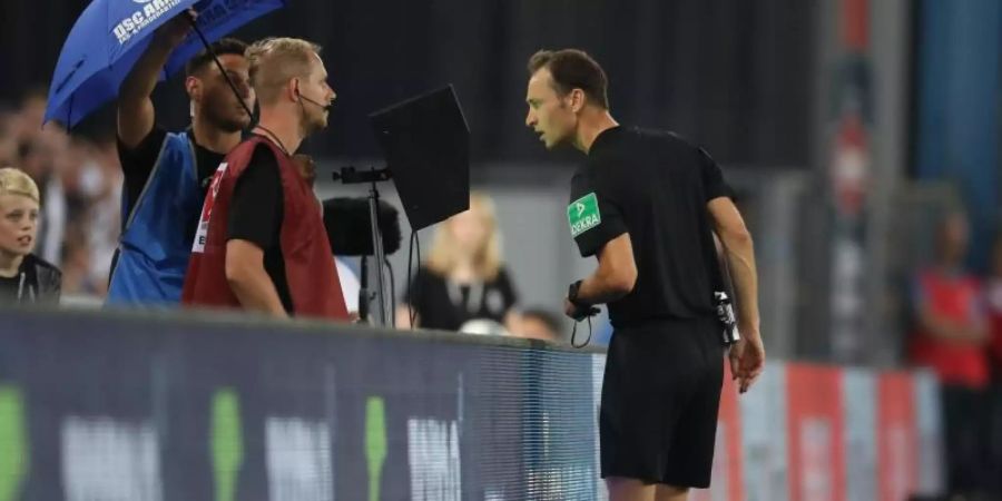 Schiedsrichter Bastian Dankert schaut sich eine strittige Szene auf dem Videomonitor an, Foto: Friso Gentsch