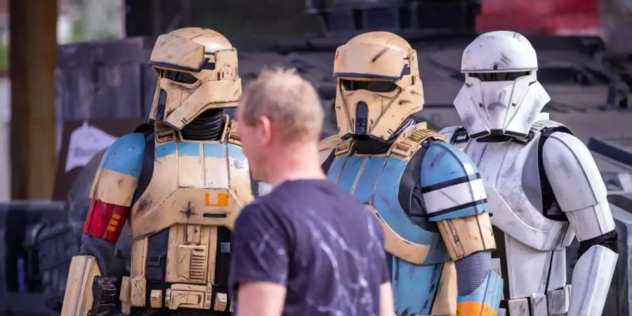 Als Sandtrooper verkleidete Mitglieder des Legion501 beobachten einen Besucher des Fanprojekts «Outpost One» mit Nachbildungen aus «Star Wars»-Filmen. Foto: Jens Büttner