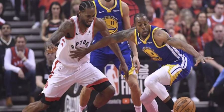 Raptors-Star Kawhi Leonard (l) im Kampf um den Ball mit Andre Iguodala (r) von den Warriors. Foto: Frank Gunn/The Canadian Press