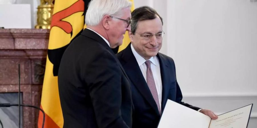 Bundespräsident Frank-Walter Steinmeier (l.) verleiht das Bundesverdienstkreuz an den ehemaligen EZB-Präsidenten Mario Draghi. Foto: Britta Pedersen/dpa-Zentralbild/dpa