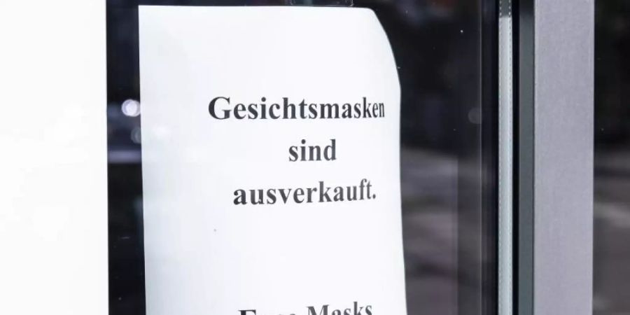 Eine Kieler Apotheke erspart ihren Kunden einen unnötigen Weg: «Gesichtsmasken sind ausverkauft - Face masks out of stock» heisst es neben der Eingangstür. Foto: Frank Molter/dpa