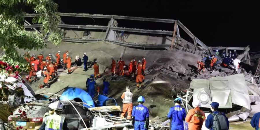 Rettungskräfte arbeiten an der Unfallstelle des eingestürzten Hotels. Foto: Lin Shanchuan/XinHua/dpa