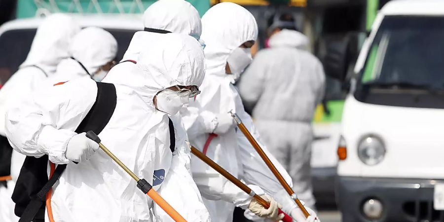 Südkoreanische Arbeiter sprühen Desinfektionsmittel in den Strassen von Gwangju. Die Weltbank stellt Soforthilfe im Kampf gegen das sich rasch ausbreitende Coronavirus bereit. (Foto: Shin Dae-hee/AP Keystone-SDA)