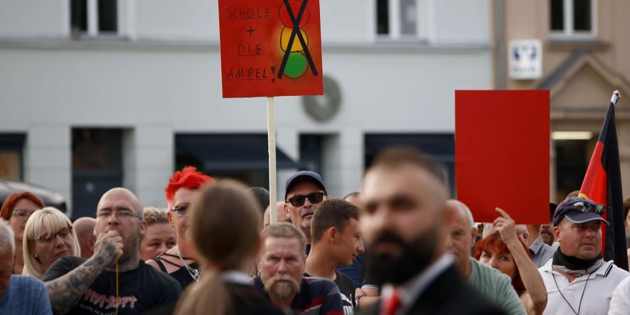 Zuschauer protestieren während der Rede von Bundeskanzler Olaf Scholz bei einer Dialogveranstaltung Bürgern in Neuruppin.