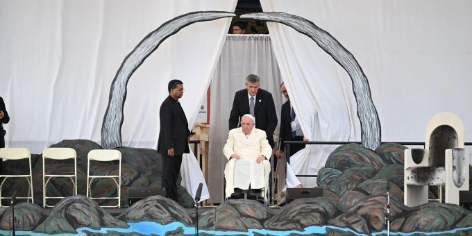 Papst Franziskus wird in seinem Rollstuhl auf die Bühne geschoben. Papst Franziskus wird in seinem Rollstuhl auf die Bühne geschoben.