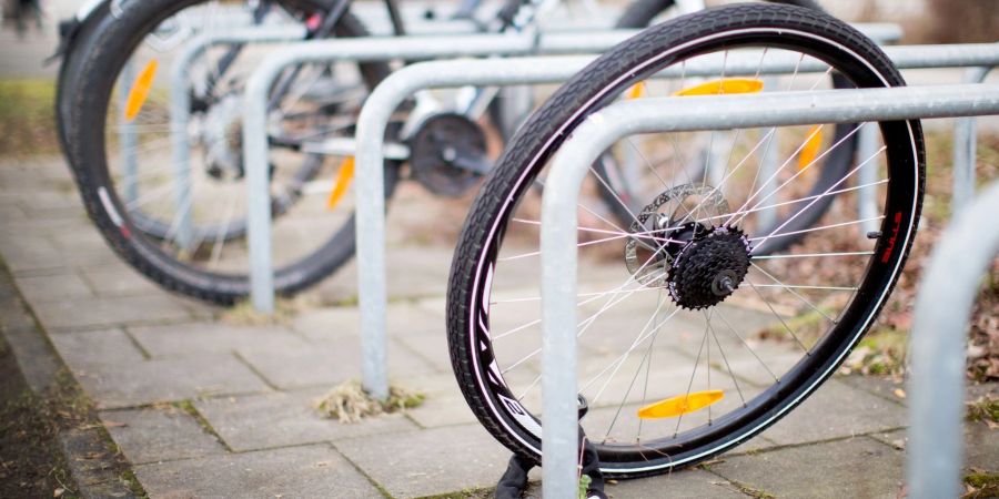 Ein zurückgelassenes Hinterrad von einem Fahrrad steht nach einem Fahrraddiebstahl an einem Fahrradständer.