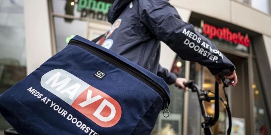 Ein Fahrer des Medikamenten-Lieferservice MAYD steht vor einer Apotheke. Per Mayd-App können Patienten rezeptfreie Medikamente bei ihrer Apotheke vor Ort bestellen. Foto: Fabian Sommer/dpa