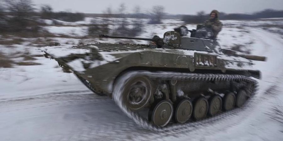 Ukrainische Soldaten fahren mit einem gepanzerten Mannschaftstransportwagen durch den Schnee. Foto: Vadim Ghirda/AP/dpa