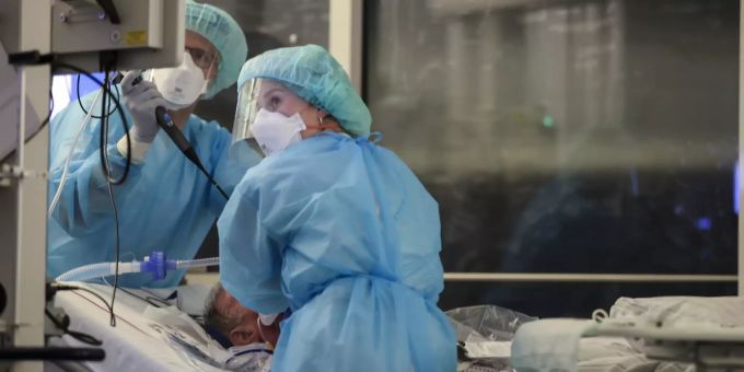 Zwei Pflegfachangestellte helfen einem Covid-Patienten. Pflegeinitiatvie