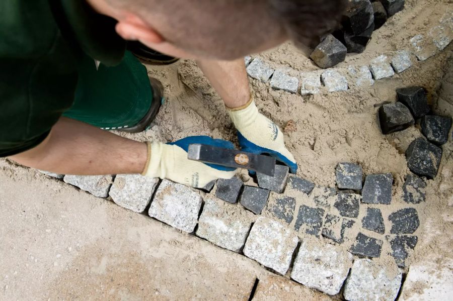 Männer bauen einen Gartenweg.