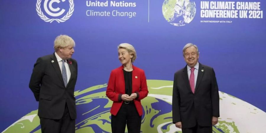 Der britische Premierminister Boris Johnson (l) und der Generalsekretär der Vereinten Nationen, Antonio Guterres, begrüssen die Präsidentin der Europäischen Kommission, Ursula von der Leyen (CDU), bei ihrer Ankunft zum UN-Klimagipfel COP26 in Glasgow. Foto: Christopher Furlong/Pool Getty/AP/dpa