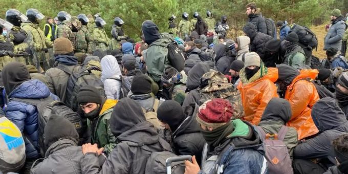 Migranten sitzen zusammen vor der Grenze in Belarus am gesperrten Übergang zu Polen. Foto: Ulf Mauder/dpa Belarus
