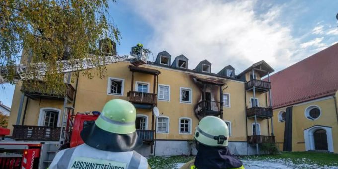 Feuerwehrmänner stehen vor einem ausgebrannten Mehrfamilienhaus. Foto: Armin Weigel/dpa Feuerwehrmänner stehen vor einem ausgebrannten Mehrfamilienhaus. Foto: Armin Weigel/dpa