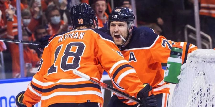 Leon Draisaitl (r) feiert mit Teamkollege Zach Hyman den Sieg der Edmonton Oilers. Foto: Jason Franson/The Canadian Press/AP/dpa