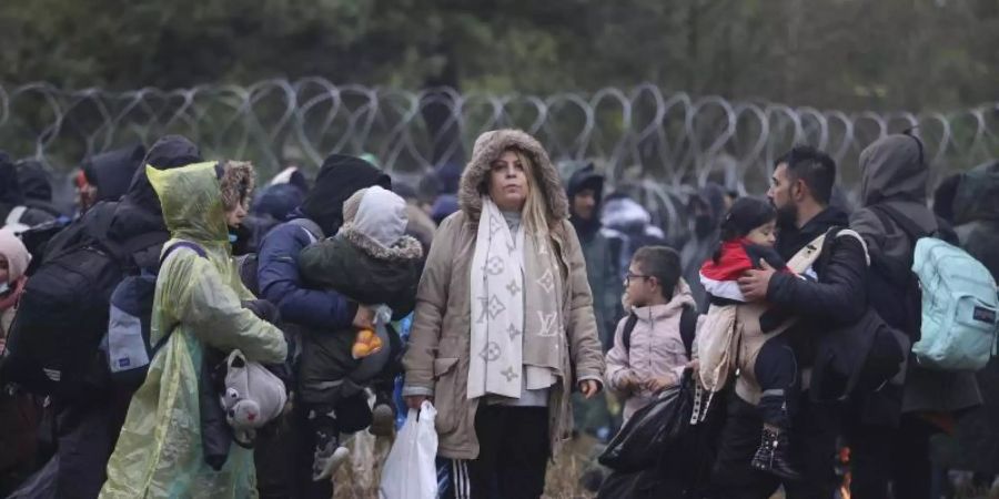 Migranten aus dem Nahen Osten und anderen Ländern versammeln sich an der belarussisch-polnischen Grenze. Polen warnt Migranten an der Grenze zu Belarus per SMS, Gerüchten über einen angeblich bevorstehenden Transit nach Deutschland nicht zu glauben. Foto: Leonid Shcheglov/BelTA/AP/dpa