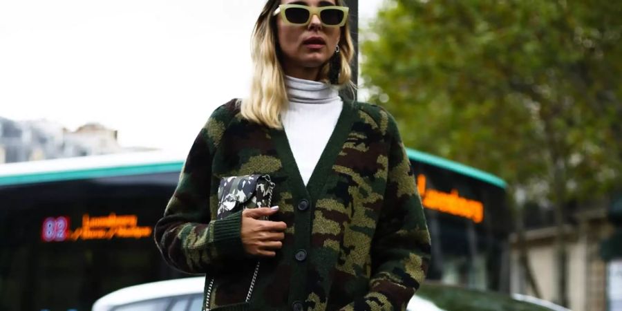 Mode-Influencerin Candela Pelizza kombiniert ihren Camouflage-Cardigan mit Lederbleistiftrock und weissem Rollkragenpullover.