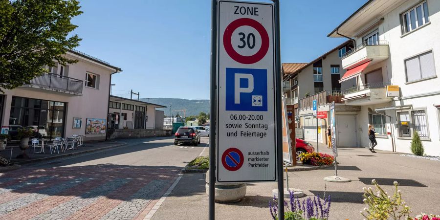 Tempo 30 Zone an der Bahnhofstrasse in Bruegg. Rechts die Post, links der Bahnhof von Bruegg.