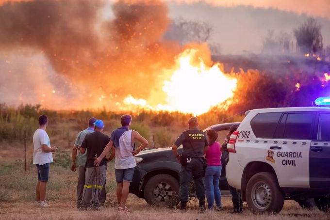 Nachbarn und Mitarbeiter des Zivilschutzes beobachten die Flammen bei einem Waldbrand in Almonaster la Real. Brände Spanien