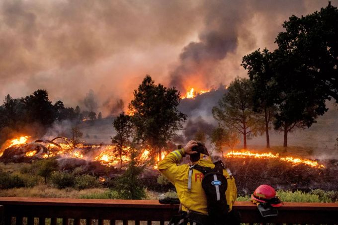 Ein Feuerwehrmann schaut auf das Feuer vor sich. Kalifornien kämpft um die Eindämmung riesiger Waldbrände und hat nun auch Hilfe aus dem In- und Ausland angefordert. Waldbrände in Kalifornien