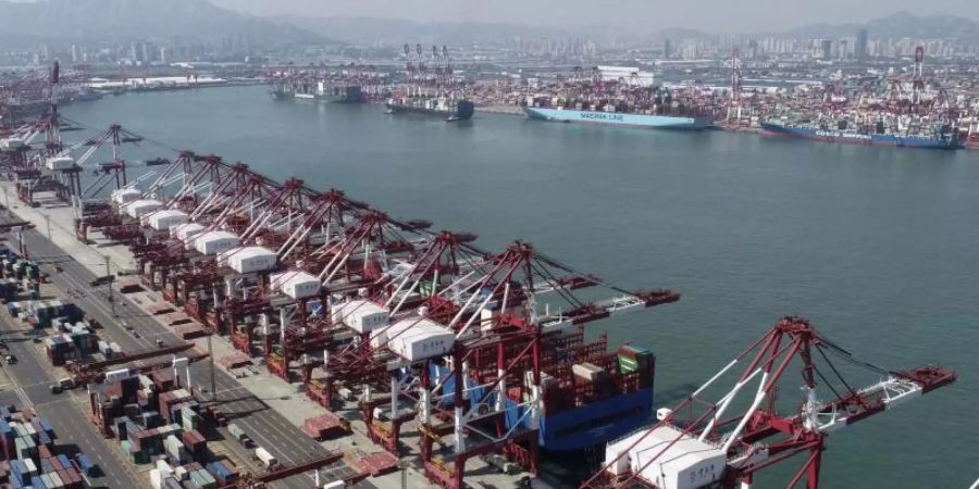 Containerschiffe werden in einem Containerhafen in Qingdao angedockt. Als Zeichen für eine anhaltende wirtschaftliche Erholung nach Überwindung der Corona-Pandemie hat Chinas Aussenhandel erneut zugelegt. Foto: Uncredited/CHINATOPIX/AP/dpa