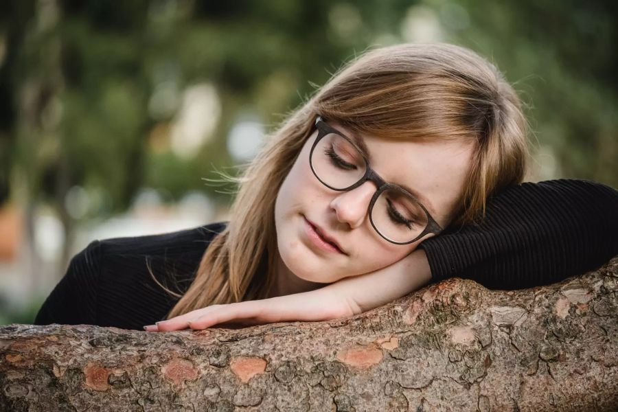 Frau liegt auf Baum