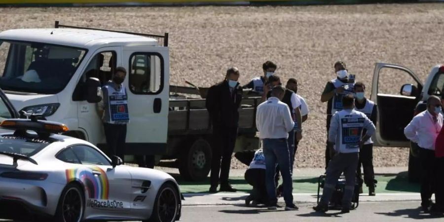 Arbeiter reparieren den losen Gullydeckel auf dem Algarve International Circuit. Foto: Rudy Carezzevoli/Pool GETTY/dpa