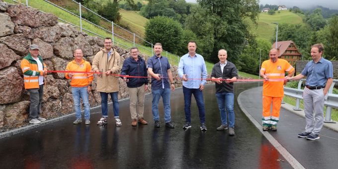 Das rote Band zur offiziellen Eröffnung der sanierten Seebodenstrasse wird durchgeschnitten, von links: Fabian Barmettler (Anliker AG), Urs Hauser (Anliker AG), Mirza Dedic (Geoinfra Ingenieure AG), Joe Widmer (Bezirk, Ressort Infrastruktur), René Hunziker (Bezirksrat Infrastruktur), Oliver Ebert (Bezirksammann), Josef Werder (Kooperation Berg und Seeboden), Oliver Schenk (Anliker AG) und Markus Tschümperlin (Geoinfra Ingenieure AG). Männer durchschneiden ein rotes Band