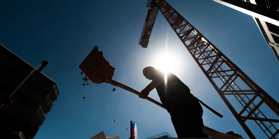 Ein Bauarbeiter leistet in der Berliner Sommerhitze körperliche Arbeit.