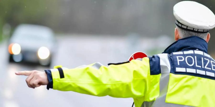 Ein Polizist während einer Geschwindigkeitskontrolle an einer Bundesstrasse. Foto: Uwe Anspach/dpa/Symbolbild