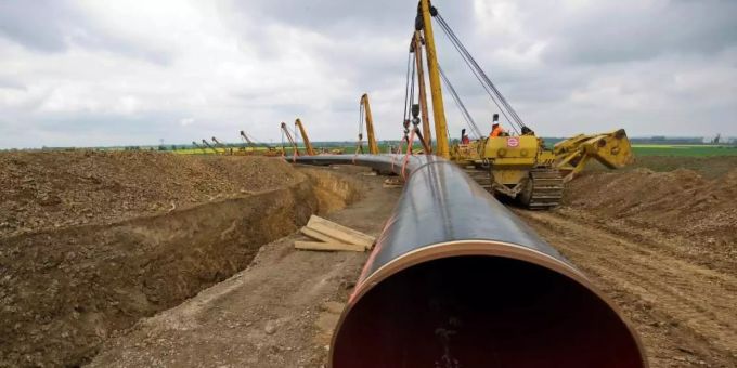 Ein Rohrstück für die Pipeline-Verlängerung Opal wird ins Erdreich verlegt (Archiv). Gasrohre