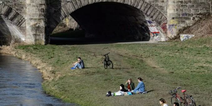 Junge Menschen geniessen am Ufer der Leine in Göttingen das milde Wetter. Foto: Swen Pförtner/dpa Junge Menschen geniessen am Ufer der Leine in Göttingen das milde Wetter. Foto: Swen Pförtner/dpa