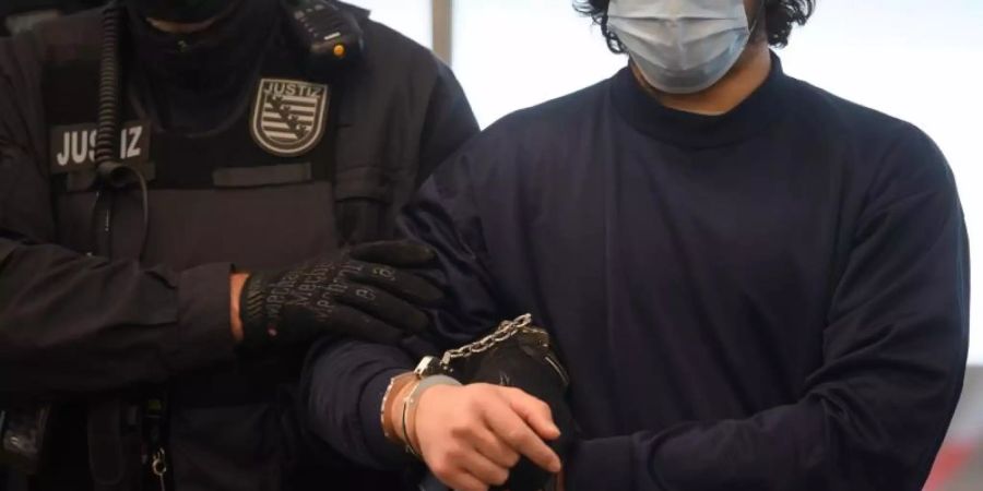 Der Angeklagte wird vor der Urteilsverkündung von Justizbeamten in den Verhandlungssaal des OLG Dresden geführt. Foto: Robert Michael/dpa-Zentralbild Pool/dpa
