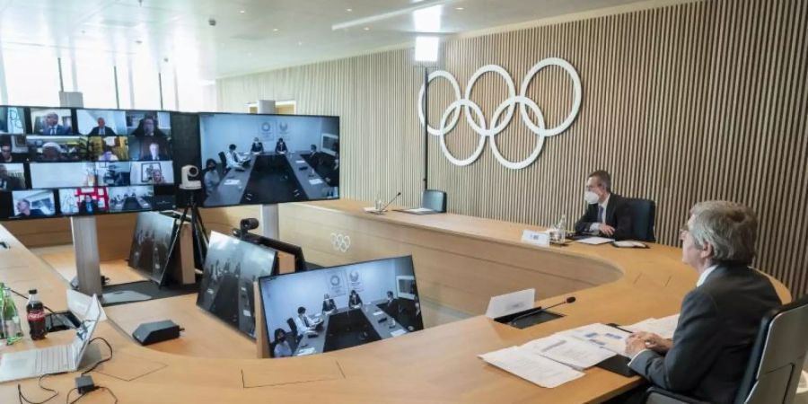 Thomas Bach (r), Präsident des Internationalen Olympischen Komitees (IOC), nimmt an der Sitzung der Exekutive des IOC per Video teil. Foto: Greg Martin/IOC/dpa