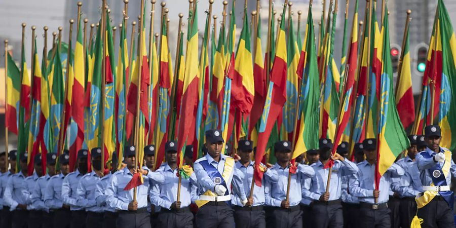 Äthiopische Polizisten, die Fahnen in den Farben der Nationalflagge halten, marschieren während einer Parade auf dem Meskel-Platz, um die neue Polizeiuniform zu präsentieren und an die Wahrung der Unparteilichkeit sowie das Respektieren des Gesetzes während der bevorstehenden Wahlen zu erinnern. Wenige Stunden vor der Wahl in Äthiopien melden die Behörden in Afrikas zweitgrösstem Land Erfolge im Kampf gegen Rebellen der Oromo-Befreiungsarmee OLA. Foto: Ben Curtis/AP/dpa